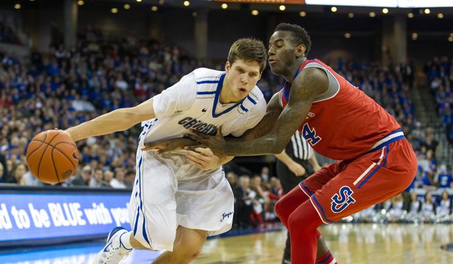 Creighton forward Doug McDermott, left, dribbles to the basket as St. John&#x27;s forward Jakarr Sampson (14) guards during the second half of an NCAA college basketball game in Omaha, Neb., Tuesday, Jan. 28, 2014. (AP Photo/John Peterson)