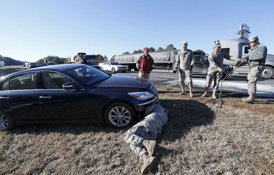 Alabama Army National Guard troops assist Tommy Holmes with his stuck vehicle on interstate 20 Thursday Jan. 30, 2014 in Leeds, Ala. The south woke up to more freezing temperatures but officials are hoping for a thaw and relief from the icy conditions. (AP Photo/Hal Yeager)