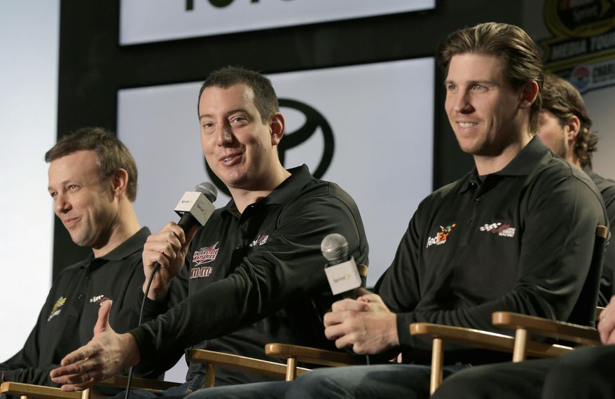 Driver Kyle Busch, center, answers a question as teammates Denny Hamlin, right, and Matt Kenseth, left, listen during a news conference at the NASCAR Sprint Cup auto racing Media Tour in Charlotte, N.C., Thursday, Jan. 30, 2014. (AP Photo)