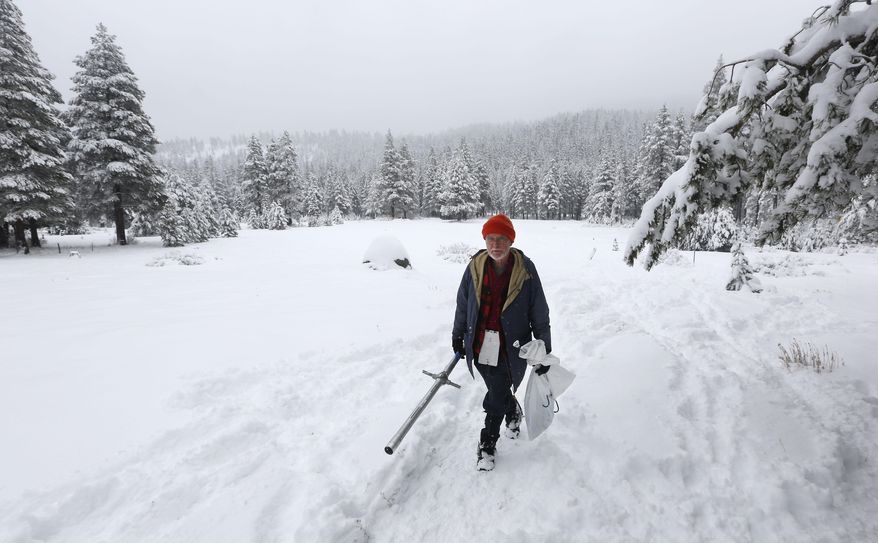 Frank Gehrke, chief of the California Cooperative Snow Survey Program for the Department of Water Resources, walks leaves a snow covered meadow after the second snow survey of the year near Echo Summit, Calif., Thursday, Jan. 30, 2014. Despite the overnight snow storm the survey showed the snow depth at 12.4 inches with a water content of only 1.4 inches for this location at this time of the year. Gehrke said that while the recent snow fall will help, it is not enough to impact the water supply.(AP Photo)