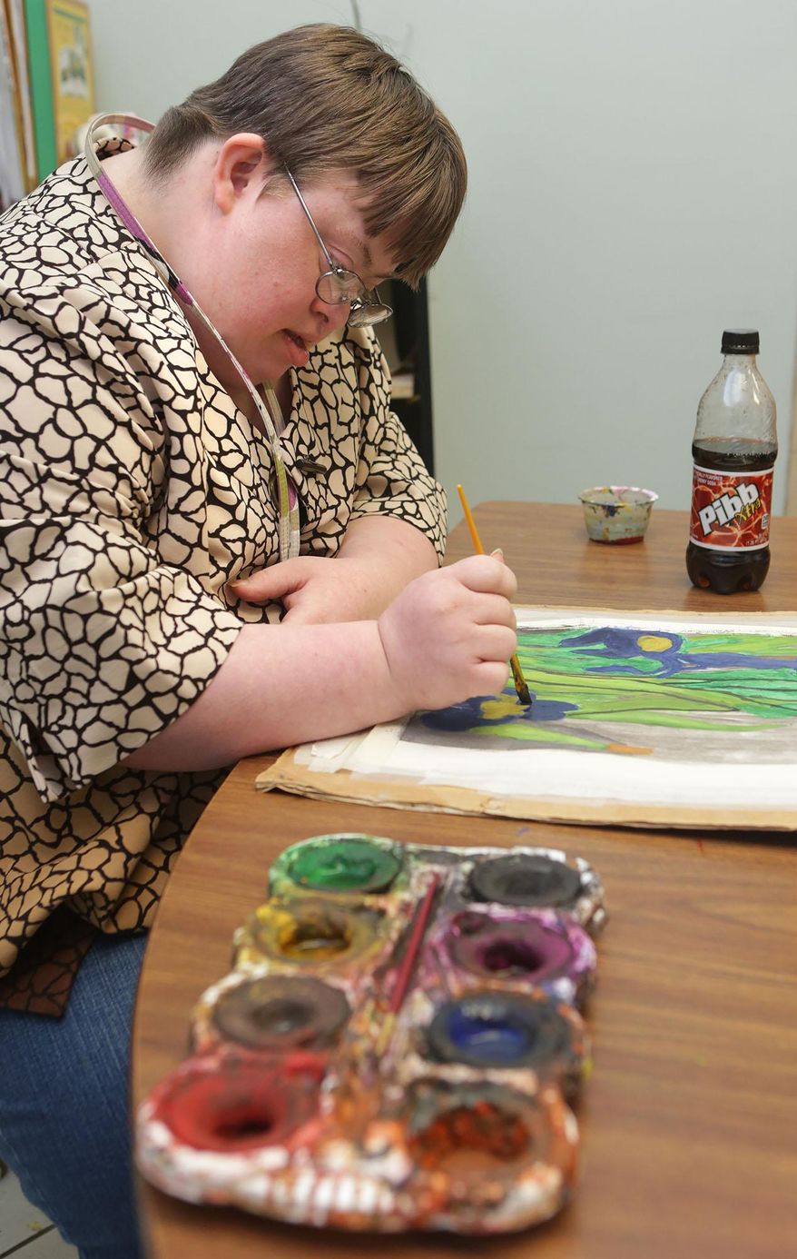 FOR RELEASE SATURDAY, FEB. 1, 2014 AT 1:14 A.M. EST - In this photo from Jan. 22, 2014, Amy Petty works on a flower painting during class at Pyramid Adult Day Training in Panama City, Fla. (AP Photo/The News Herald/Panama City, Fla., Heather Leiphart)