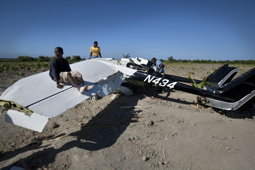 A young boy sits on the wing of a Cessna Super Skymaster that made an emergency landing the night before in a field just outside Cabaret, a coastal town northwest of Port-au-Prince, Haiti, Thursday Jan. 30, 2014. Haitian police said on Thursday that the small plane piloted by a U.S. citizen suffered mechanical problems and made an emergency landing in the banana field. Police inspector Joachin Antoine said that pilot Practor Antoine was treated for unspecified injuries at a hospital in the capital. A passenger named John Michael was not injured. (AP Photo/Dieu Nalio Chery)