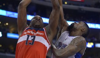 Washington Wizards center Kevin Seraphin, left, of France, puts up a shot as Los Angeles Clippers center DeAndre Jordan defends during the second half of an NBA basketball game, Wednesday, Jan. 29, 2014, in  Los Angeles. (AP Photo/Mark J. Terrill)