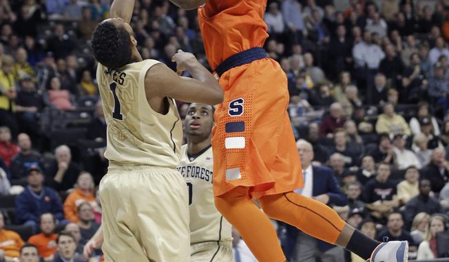 Syracuse&#x27;s C.J. Fair, right, shoots over Wake Forest&#x27;s Madison Jones, left, during the second half of an NCAA college basketball game in Winston-Salem, N.C., Wednesday, Jan. 29, 2014. Syracuse won 67-57. (AP Photo/Chuck Burton)