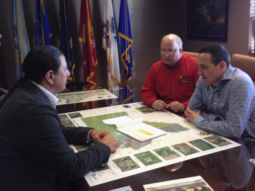 This Jan. 29, 2014 photo provided by the American Red Cross shows shows Standing Rock Sioux Tribe Chairman Dave Archambault II, left, Vice Chair Jesse McLaughlin, center, and Black Hills Red Cross Executive Director Richard Smith during a meeting in Standing Rock Reservation tribal office in Fort Yates, N.D. The meeting was to discuss the propane shortage for American Indian tribes in the Dakotas. The federal government has released more money for a program that helps low-income people heat their homes, and nearly $1.3 million is earmarked for American Indian tribes in the Dakotas. Archambault says the additional money might not be enough to deal with a propane crisis on that reservation. (AP Photo/Courtesy of the American Red Cross, Johnelle Leingang)