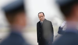 French President Francois Hollande listens to the French National Anthem before reviewing an honour guard, after his arrival for a one-day summit with Britain&#39;s Prime Minister David Cameron, not pictured, at the RAF Brize Norton airbase in Brize Norton, England, Friday, Jan. 31, 2014.  (AP Photo/Andrew Winning, Pool)