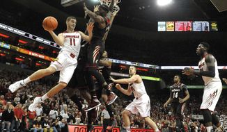 Louisville&#39;s Luke Hancock, left, passes as Cincinnati&#39;s Justin Jackson defends during the second half of an NCAA college basketball game Thursday, Jan. 30, 2014, in Louisville, Ky. Cincinnati defeated Louisville 69-66. (AP Photo/Timothy D. Easley)