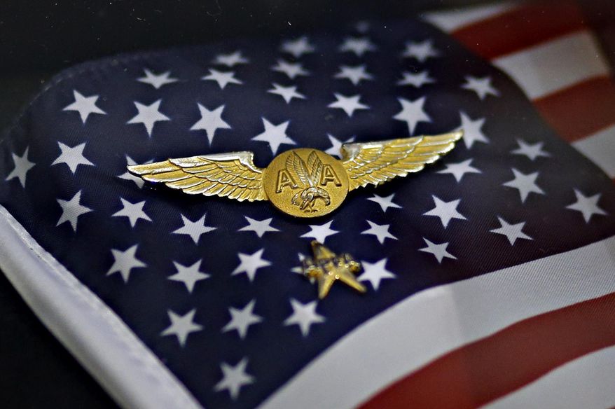 Two pins belonging to American Airlines flight attendants rest on a small flag in a display case Thursday, Jan. 30, 2014 at the C.R. Smith Museum in Fort Worth, Texas. The pins were recovered from the Pentagon wreckage, and were returned to the airline and put on display at the museum. (AP Photo/The Dallas Morning News, G.J. McCarthy) MANDATORY CREDIT