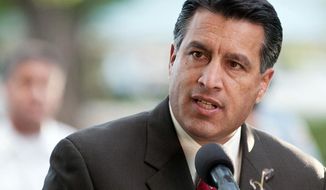 File-In this Sept. 25, 2011 file photo Nevada Gov. Brian Sandoval speaks during a memorial service in Reno, Nev.  Sandoval is defending his decision to allow the use of a Nevada Air National Guard aircraft to fly a critically ill woman to an Oregon hospital for life-saving treatment.  (AP Photo/Kevin Clifford,File)