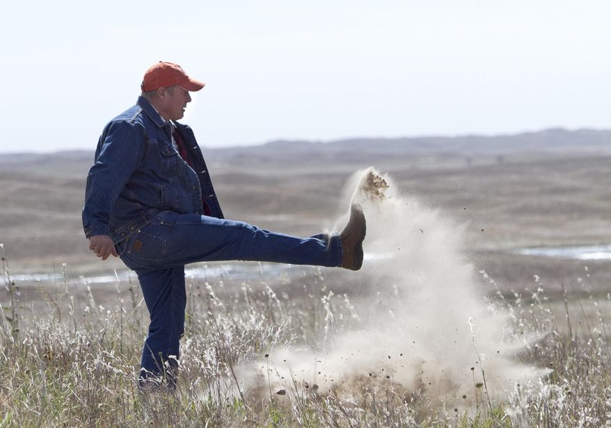 FILE - In this Sept. 29, 2014 file photo Atkinson, Neb., rancher Bruce Boettcher, who opposes the Keystone XL pipeline, kicks up sand on his land, to demonstrate the fragility of the sand hills near the planned route of the pipeline. The long-delayed Keystone XL oil pipeline cleared a major hurdle Friday, Jan. 31, 2015 as the U.S.State Department raised no major environmental objections to the controversial pipeline from Canada through the heart of the U.S. Republicans and some oil- and gas-producing states cheered, but the report further rankled environmentalists already at odds with President Barack Obama. (AP Photo/Nati Harnik, File)