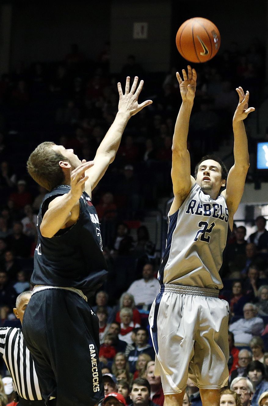 Mississippi guard Marshall Henderson (22) shoots as a South Carolina player defends in the first half of an NCAA college basketball game in Oxford, Miss., Saturday, Feb. 1, 2014. (AP Photo/Rogelio V. Solis)