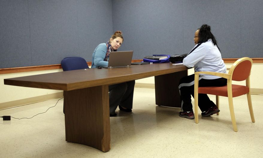 Amanda Deardorff, left, a health enrollment navigator with Open Door Health Solutions, helps Vicki Bonner through the process of signing up for coverage under the Affordable Care Act in Muncie, Ind., on Dec. 26, 2013. Nearly 17 percent of the state's population, or 911,674 people, lacks insurance. Most of those residents are required to show proof they've obtained insurance after March to avoid a penalty under the federal health care overhaul law. But the U.S. Department of Health and Human Services says only about 30,400 residents had bought plans through the exchange in through the end of December. (AP Photo/AJ Mast)