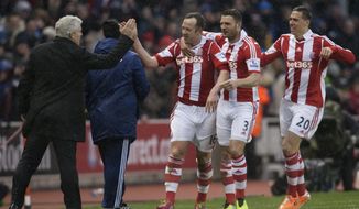 Stoke&#39;s Charlie Adam, centre, celebrates with teammates and manager Mark Hughes, left, after scoring his second goal against Manchester United during their English Premier League soccer match at the Britannia Stadium, Stoke, England, Saturday Feb. 1, 2014. (AP Photo/Jon Super)