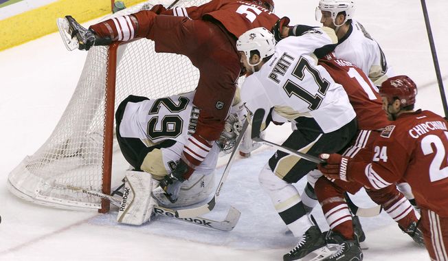 Phoenix Coyotes&#x27; Connor Murphy (5) collides with Pittsburgh Penguins goaltender Marc-Andre Fleury (29) as Penguins&#x27; Taylor Pyatt (17) and Brooks Orpik, second from right, chase down the puck ahead of Coyotes&#x27; Jeff Halpern (14) and Kyle Chipchura (24) during the second period of an NHL hockey game on Saturday, Feb. 1, 2014, in Glendale, Ariz. (AP Photo/Ralph Freso)