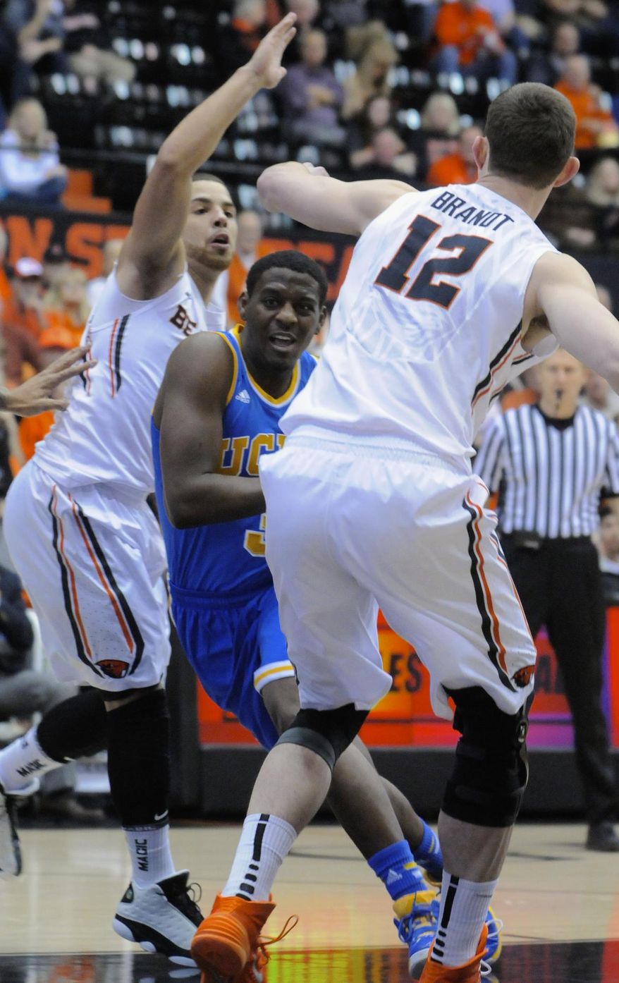 UCLA's Jordan Adams (3) drives against Oregon State's Angus Brandt (12) and Roberto Nelson during the first half of an NCAA college basketball game in Corvallis, Ore., Sunday, Feb. 2, 2014. (AP Photo/Greg Wahl-Stephens)