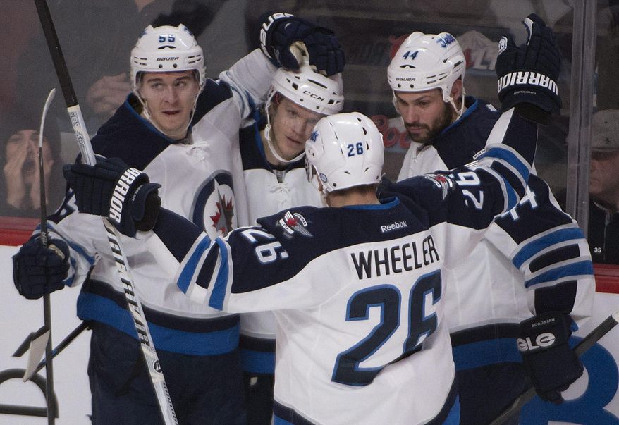 Winnipeg Jets' Tobias Enstrom, second from left, gets congratulated by teammates Mark Scheifele (55), Blake Wheeler (26) and Zach Bogosian (44) after scoring against the Montreal Canadiens during second period NHL action in Montreal, Sunday, Feb. 2, 2014. (AP Photo/The Canadian Press, Peter Mccabe)