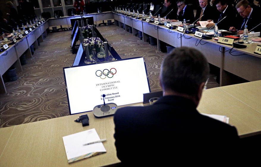International Olympic Committee President Thomas Bach, near, sits down to start an executive board meeting at the 2014 Winter Olympics, Sunday, Feb. 2, 2014, in Sochi, Russia. (AP Photo/David Goldman)