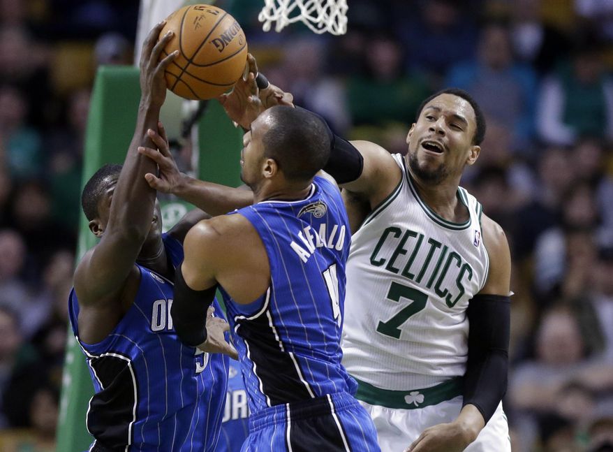 Boston Celtics center Jared Sullinger (7) grapples with Orlando Magic guard Victor Oladipo, behind left, and guard Arron Afflalo, center, for control of the ball in the third quarter of an NBA basketball game on Sunday, Feb. 2, 2014, in Boston. The Celtics won 96-89. (AP Photo/Steven Senne)