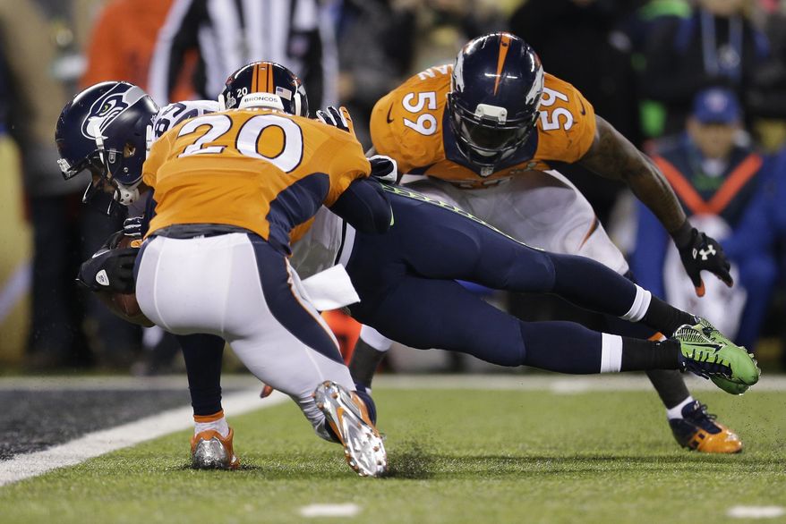 Seattle Seahawks' Doug Baldwin dives between Denver Broncos' Mike Adams, left, and Danny Trevathan for a touchdown during the second half of the NFL Super Bowl XLVIII football game Sunday, Feb. 2, 2014, in East Rutherford, N.J. (AP Photo/Julio Cortez)