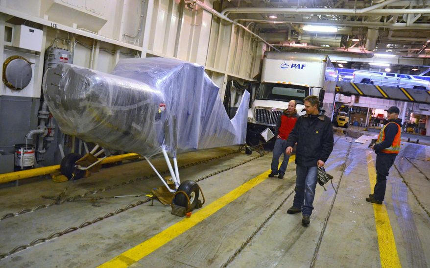 ADVANCE FOR MONDAY FEB. 3 - In this Jan. 22, 2014 photo, James Jackson inspects his airplane after it was secured to the car deck of the ferry Tustumena at City Pier 1 in Kodiak, Alaska. The plane is bound for Talkeetna in an unusual over-the-ocean voyage. (AP Photo/Kodiak Daily Mirror, James Brooks)