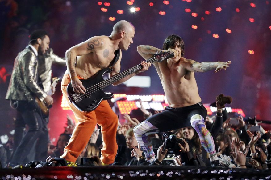 The Red Hot Chili Peppers band members Flea, center, and Anthony Kiedis perform during the halftime show of the NFL Super Bowl XLVIII football game Sunday, Feb. 2, 2014, in East Rutherford, N.J. (AP Photo/Julio Cortez)