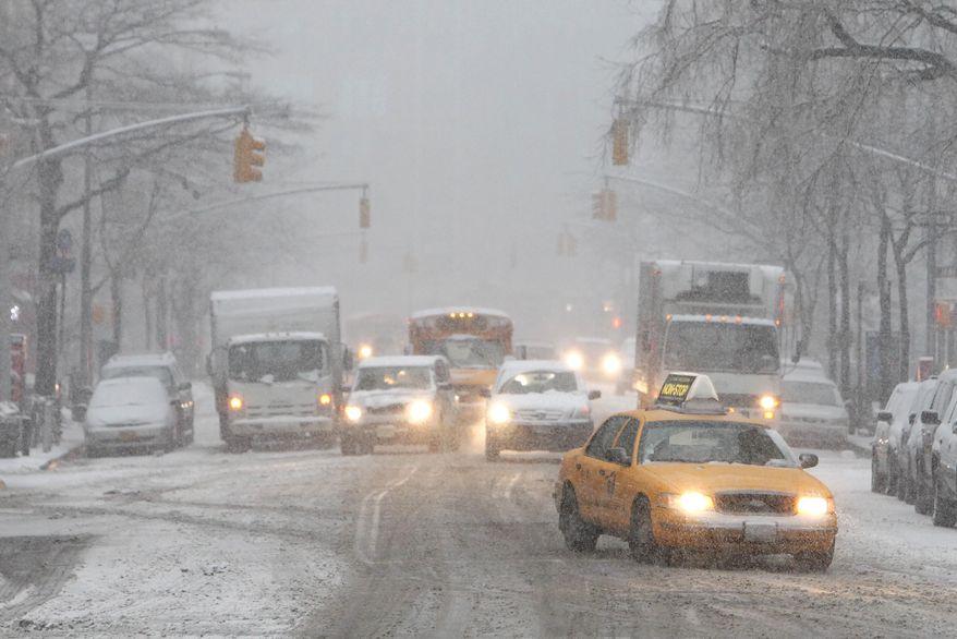 Traffic makes its way slowly down Hudson Street as heavy snow falls Monday, Feb. 3, 2014, in New York. After several days of mild weather, snow has returned to the Northeast. (AP Photo/Jason DeCrow)