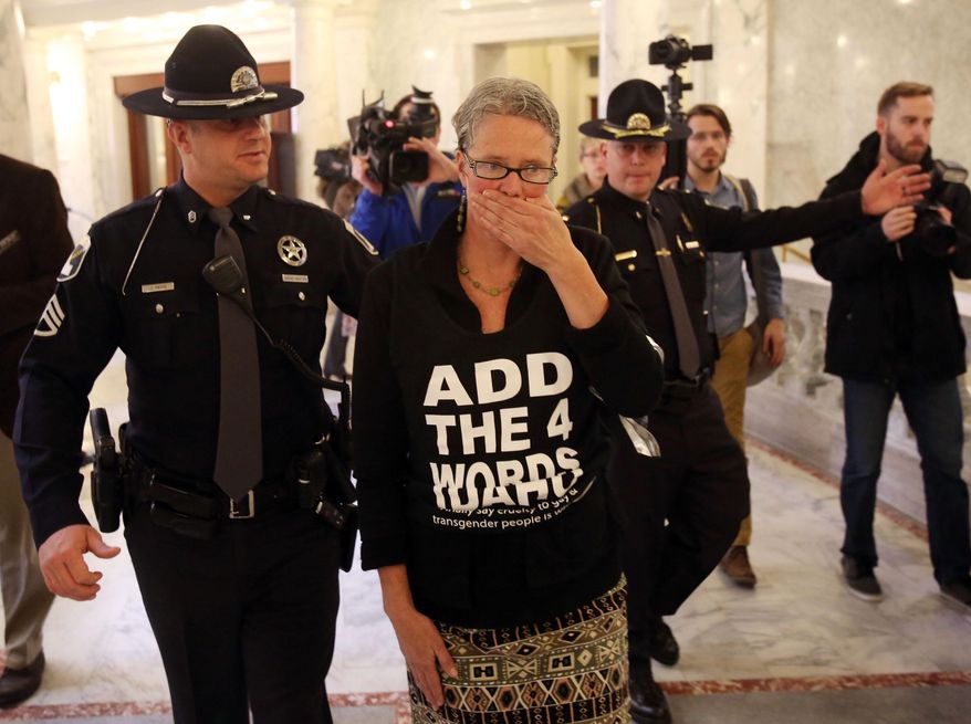 Former Idaho state Sen. Nicole LeFavour is arrested after blocking the entrance of the Senate chambers at the Idaho Statehouse on Monday, Feb. 3, 2014, in Boise, Idaho. She was part of a group of protestors who blocked the entrance while advocating adding gender identity and sexual orientation to the state's human rights ordinance. They cover their mouths to symbolize their feelings of disenfranchisement. (AP Photo/The Idaho Statesman, Joe Jaszewski) LOCAL TV OUT (KTVB 7)