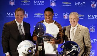 Left to right, NFL Commissioner Roger Goodell, Seattle Seahawks linebacker Malcolm Smith, and Seahawks head coach Pete Carroll pose for photos during the Super Bowl Most Valuable Player and winning coach press conference, Monday, Feb. 3, 2014, in New York. (AP Photo/Doug Benc)