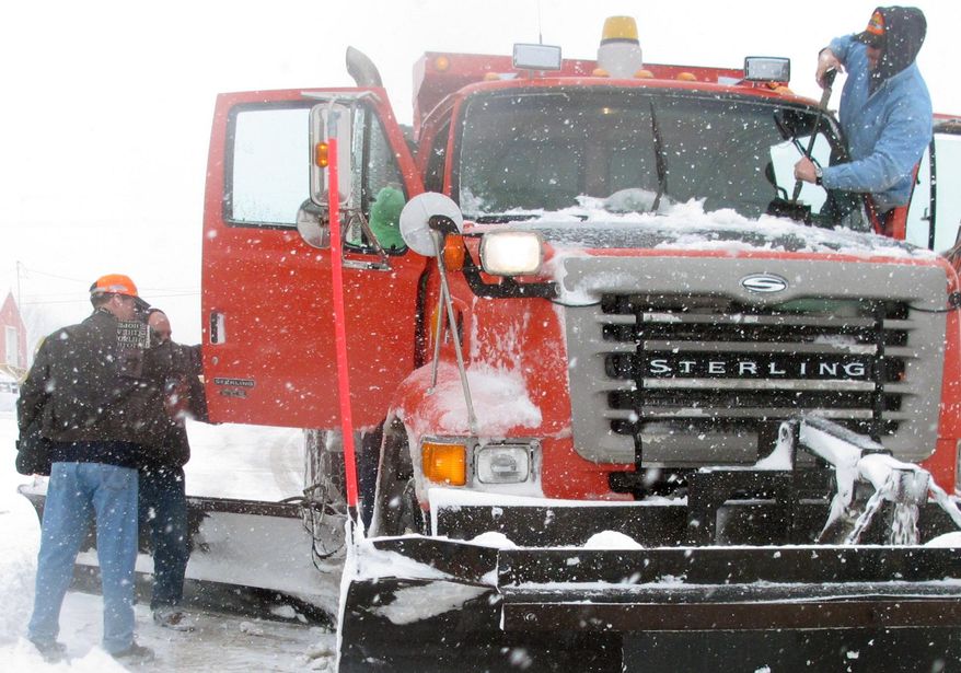 Kansas Gov. Sam Brownback, left, in the orange cap, boards a state Department of Transportation plowing truck to observe snow removal efforts along Interstate 70, Tuesday, Feb. 4, 2014, in Topeka, Kan. A winter storm has closed schools and state government offices. (AP Photo/John Hanna)