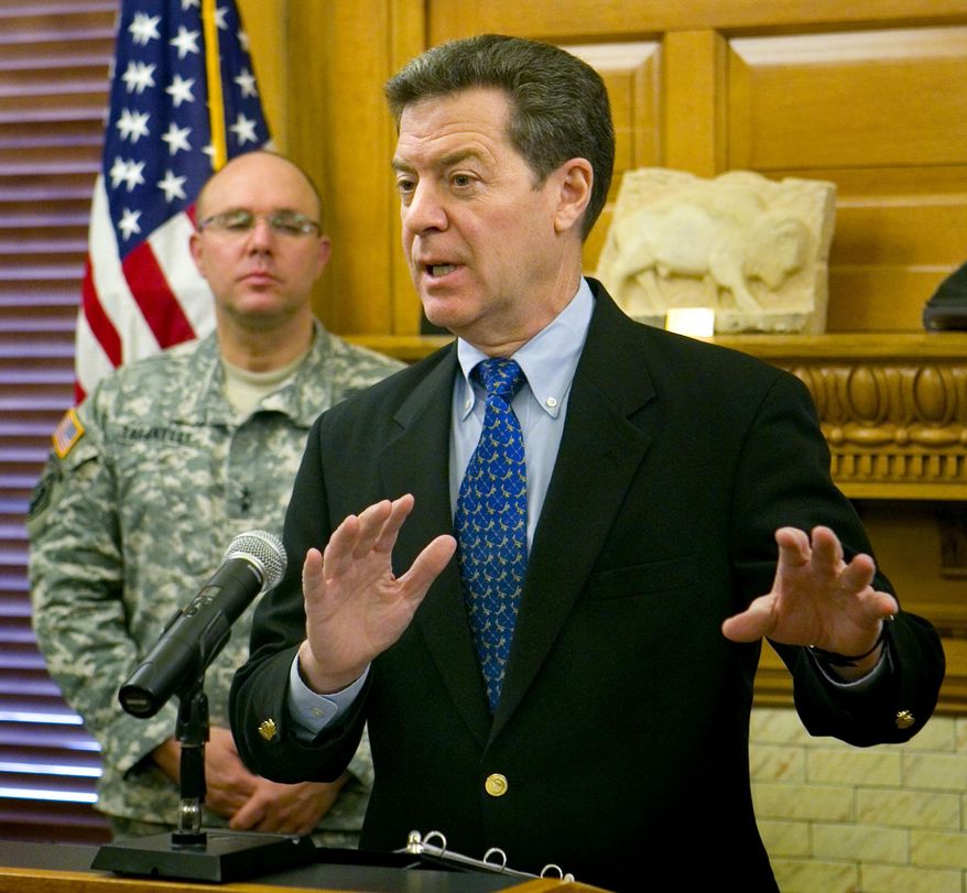 Gov. Sam Brownback announced Monday afternoon, Feb. 3, 2014, that state offices will be closed Tuesday in preparation for a major winter storm system that is forecast to hit the state Friday. Maj. Gen. Lee Tafanelli, the adjutant general and director of the Kansas Division of Emergency Management, rear, asked Kansans to make sure their home emergency kit is stocked for everyone in the household for a minimum of three days. (AP Photo/The Topeka Capital Journal, Thad Allton)