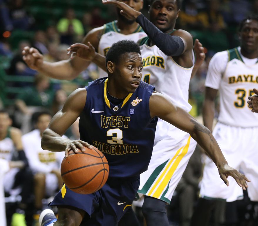 FILE - In this Jan. 28, 2014, file photo, West Virginia guard Juwan Staten (3) drives past Baylor guard Gary Franklin (4) during the first half of an NCAA college basketball game in Waco, Texas. Staten has been delivering clutch performances to lift the Mountaineers into the upper tier of the Big 12 standings with a test looming against No. 21 Oklahoma on Wednesday night. (AP Photo/Waco Tribune Herald, Rod Aydelotte, File)