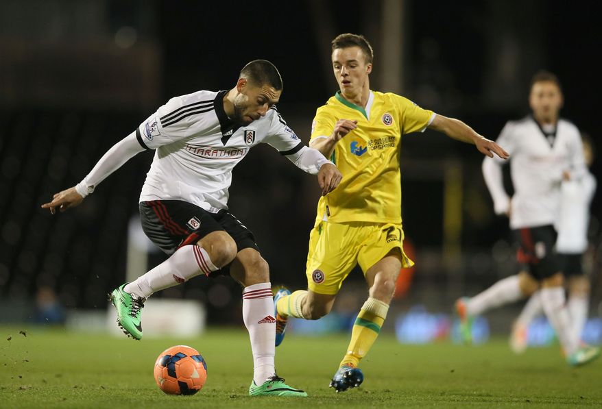 Fulham's Clint Dempsey, left, shields the ball from Sheffield United's Stefan Scougall during their 4th round replay English FA Cup soccer match between Fulham and Sheffield United at Craven Cottage stadium in London, Tuesday, Feb. 4, 2014. (AP Photo/Alastair Grant)