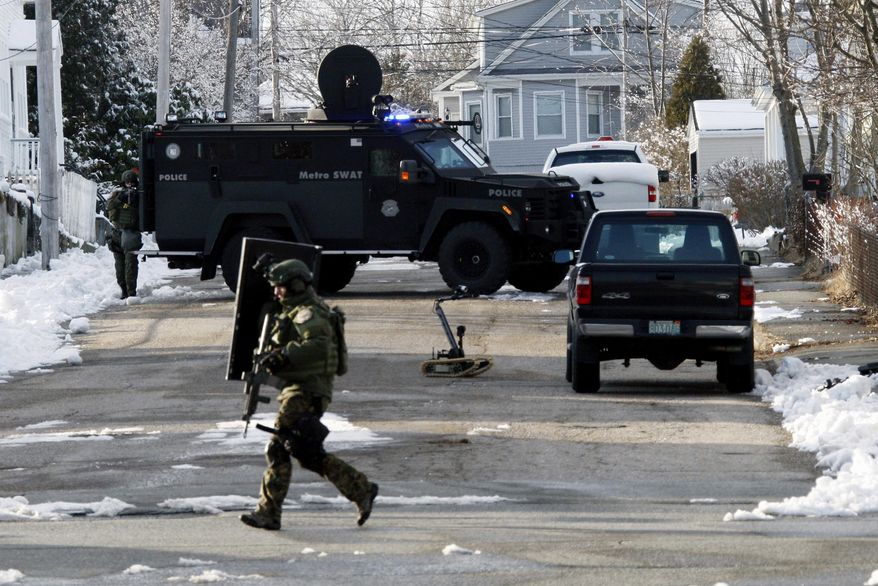 Police stand guard in the area of Richard and Hemlock streets, Tuesday, Feb. 4, 2014, in Dartmouth, Mass., during a standoff with a man who had made threats “to shoot up” Roger Williams University's campuses in Bristol and Providence, R.I. Dartmouth Police Chief Timothy Lee said the man surrendered peacefully after a six-hour standoff at his home. (AP Photo/The Standard-Times, John Sladewski)