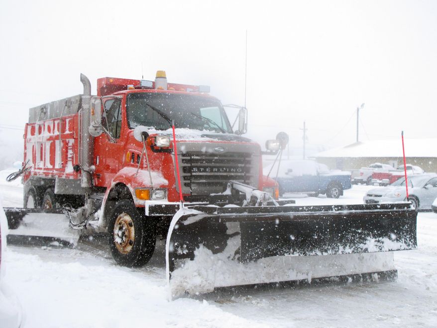 A Kansas Department of Transportation plowing truck with Gov. Sam Brownback aboard heads toward Interstate 70 to remove snow, Tuesday, Feb. 4, 2014, in Topeka, Kan. A winter storm has closed schools and state government offices. (AP Photo/John Hanna)