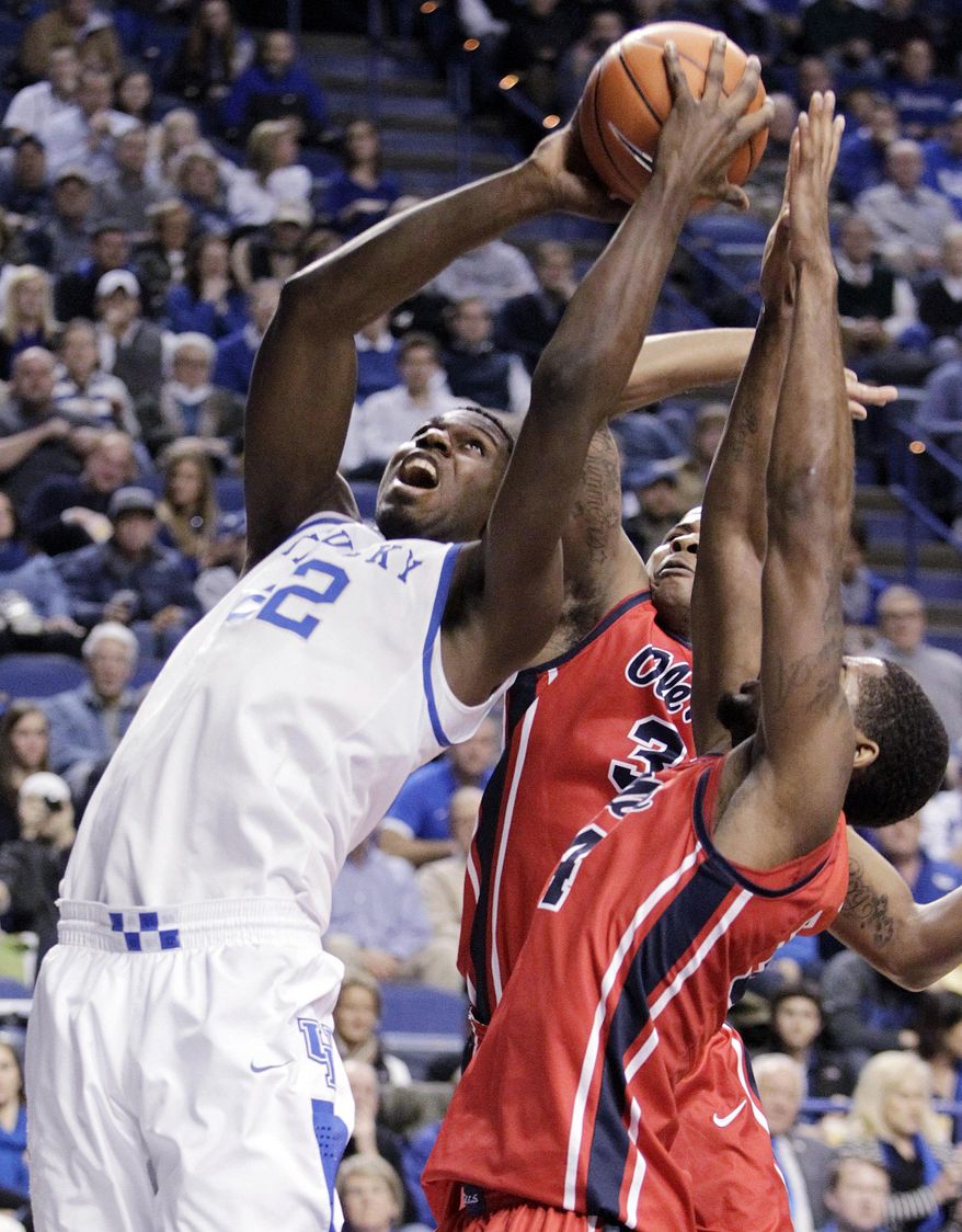 CORRECTS DAY TO TUESDAY Kentucky's Alex Poythress, left, looks for an opening on Mississippi's Jarvis Summers and Aaron Jones, right, during the first half of an NCAA college basketball game, Tuesday, Feb. 4, 2014, in Lexington, Ky. (AP Photo/James Crisp)