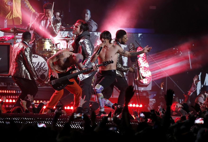 FILE - In this Sunday, Feb. 2, 2014 file photo, The Red Hot Chili Peppers perform during the halftime show of the NFL Super Bowl XLVIII football game between the Seattle Seahawks and the Denver Broncos, in East Rutherford, N.J. Flea says in a Tuesday, Feb. 4, 2014, letter to fans that the Rock and Roll Hall of Fame members pretended to play along to a pre-taped track of "Give It Away" during the Super Bowl halftime show as Anthony Kiedis sang live. The request came from NFL officials who felt it was too difficult to pull off a completely live performance because of potential sound issues. (AP Photo/Kathy Willens, File)
