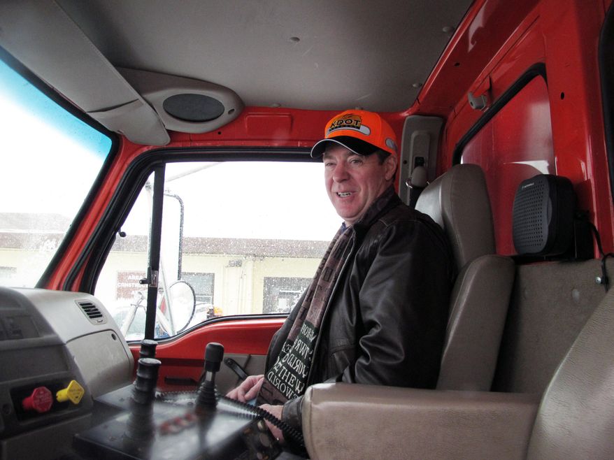 Kansas Gov. Sam Brownback sits in the cab of a state Department of Transportation plowing truck as he waits for it to start removing snow along Interstate 70, Tuesday, Feb. 4, 2014, in Topeka, Kan. A winter storm has left roads in northeast Kansas packed with snow. (AP Photo/John Hanna)