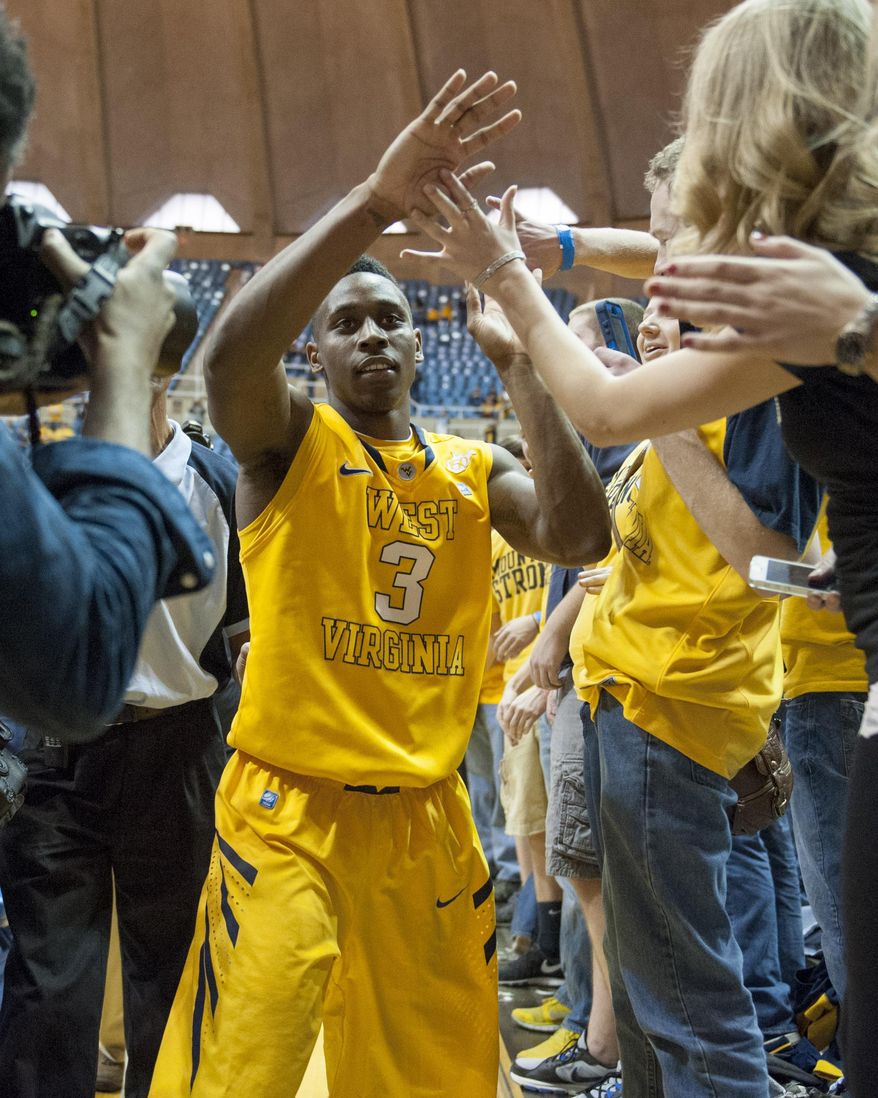 West Virginia's Juwan Staten (3) celebrates with fans an NCAA college basketball game against Kansas State, Saturday, Feb. 1, 2014, in Morgantown, W.Va. West Virginia won 81-71. (AP Photo/Andrew Ferguson)