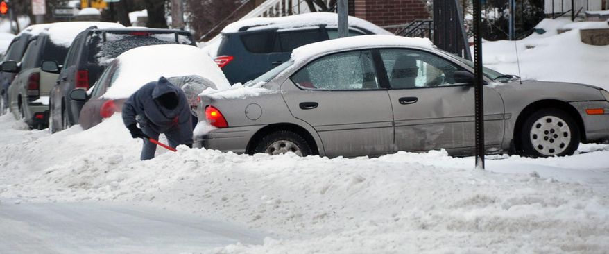 A resident helps a motorist drive out of her driveway on West Diamond Avenue in Hazleton, Pa., during a winter storm that covered the area with over 8 inches of snow on Wednesday, Feb. 5, 2014. Sleet and freezing rain fell on a fresh coat of snow from a Monday storm, giving trees a wintry frosting but also adding weight to branches. (AP Photo/Hazleton Standard-Speaker, Ellen F. O'Connell)