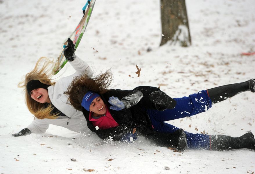 Apollo High School sophomore Tatum Champman, 15, left, and junior Keeonna Rynonlds, 17, tumble while sledding on an icy hill Tuesday afternoon, Feb. 4, 2014, at Chautauqua Park in Owensboro, Ky. Kentucky is bracing for more snow in the west and ice through other parts of the state as the latest winter blast moves through.(AP Photo/The Messenger-Inquirer, John Dunham)