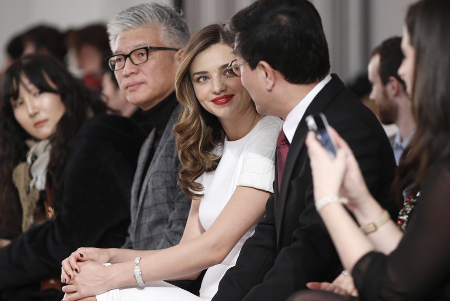 Supermodel Miranda Kerr, center, sits with Korean business executives during the presentation of the GS Shop Lingerie show featuring Spanx, Wonderbra, Platex and Anna Sui during Fashion Week Tuesday, Feb. 4, 2014, in New York. GS shop is the third largest retailer in the world. (AP Photo/Kathy Willens)
