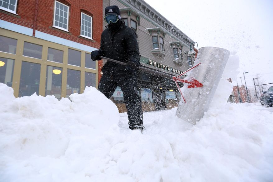 Earl Barnes shovels snow off the sidewalk in front of Smith's Market on S. Main St. in Hutchinson, Kan., Tuesday, Feb. 4, 2014. The winter storm dumped more than 10 inches of snow on the city from late Monday to late Tuesday. (AP Photo/The Hutchinson News, Travis Morisse)