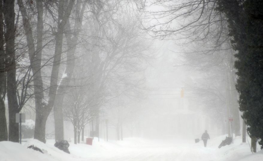 A person shovels snow on South Warren, Wednesday, Feb. 5, 2014, in Saginaw, Mich. (AP Photo/The Saginaw News, Tim Goessman)