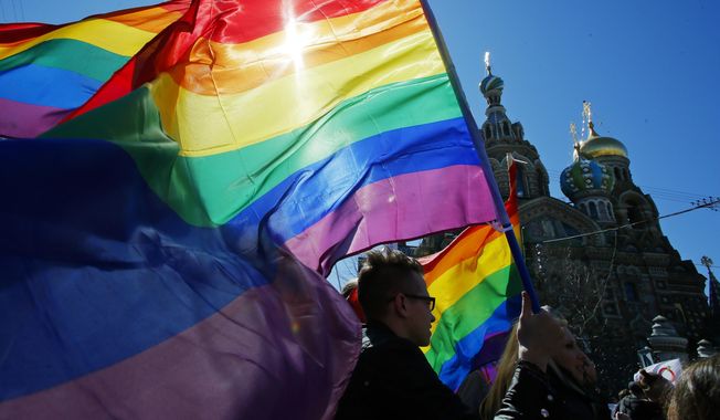 In this Wednesday, May 1, 2013, file photo, gay rights activists carry rainbow flags as they march during a May Day rally in St. Petersburg, Russia. (AP Photo/Dmitry Lovetsky, File)