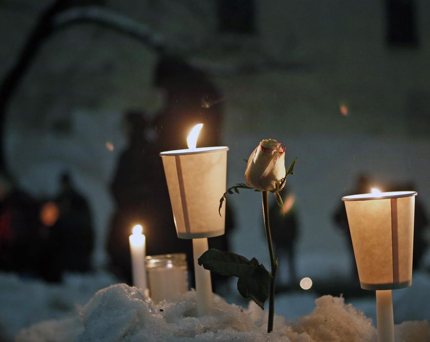 Candles burn alongside a rose left in a snowbank following a candlelight vigil sponsored by the Labyrinth Theater Company in the courtyard of the Bank Street theater for actor Philip Seymour Hoffman, a company member and former Labyrinth artistic director, Wednesday, Feb. 5, 2014, in New York. Hoffman died on Sunday of a suspected drug overdose. (AP Photo/Kathy Willens)