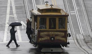 A man carries an umbrella as he walks toward a Cable Car in San Francisco, Thursday, Feb. 6, 2014. Drought-stricken California is getting some help from the weather, although forecasters say the rain and snow will not be enough to make up for one of the driest rainy seasons so far. (AP Photo/Jeff Chiu)
