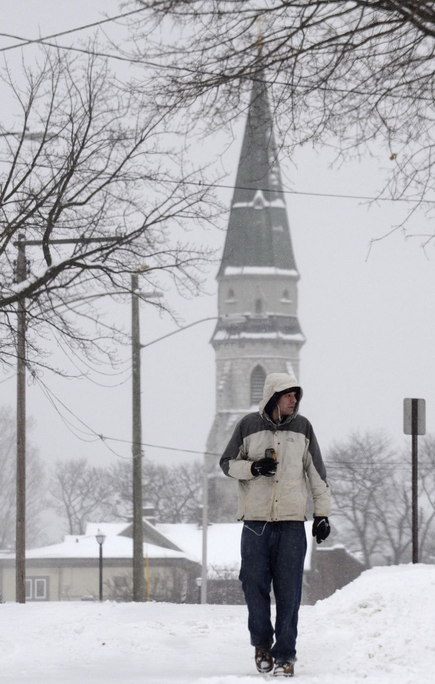 Gergory Cyr walks on Bradford Street as snow falls in Pittsfield, Mass., Wednesday Feb. 5, 2014. The storm is expected to drop a foot or more of snow on some areas of the state. (AP Photo/The Berkshire Eagle, Ben Garver)