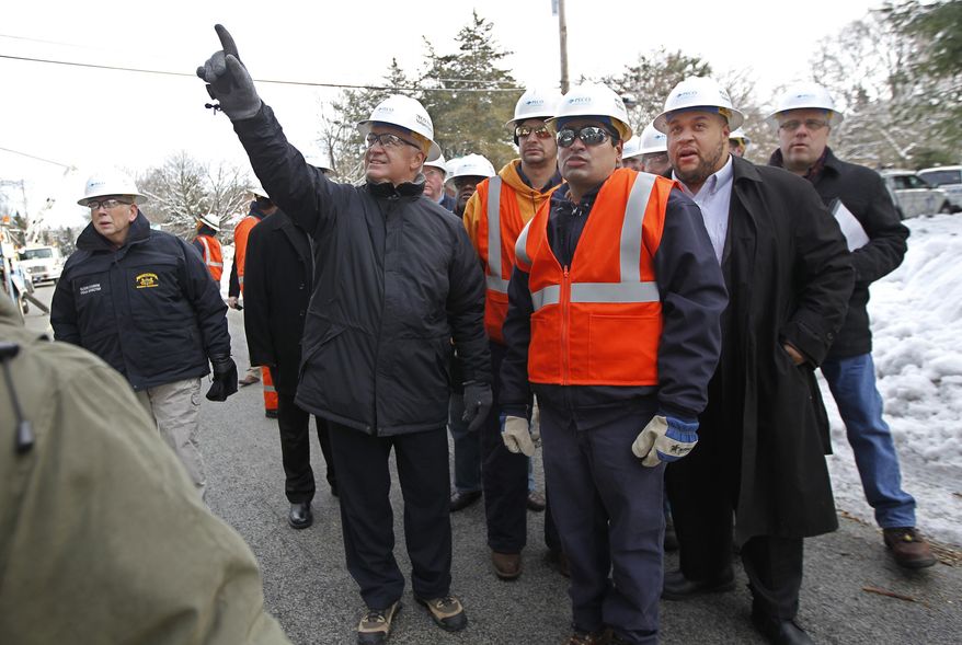 Pennsylvania Governor Tom Corbett, left, points to the PECO linemen repairing the overhead power lines on Union Meeting Road in Blue Bell, Pa., and talks to Steven Singh, right, about the process of restoring power to Southeastern Pennsylvania on Feb. 6, 2014. Singh is the PECO Director of Electrical Distribution for Bucks and Montgomery Counties. The recovery continues after the ice storm which left 500,000 without power. Gov. Corbett visits Montco, Pa., one of the hardest hit areas, as PECO warns customers that some will be without power for several more days. (AP Photo/Philadelphia Inquirer, Michael Bryant)