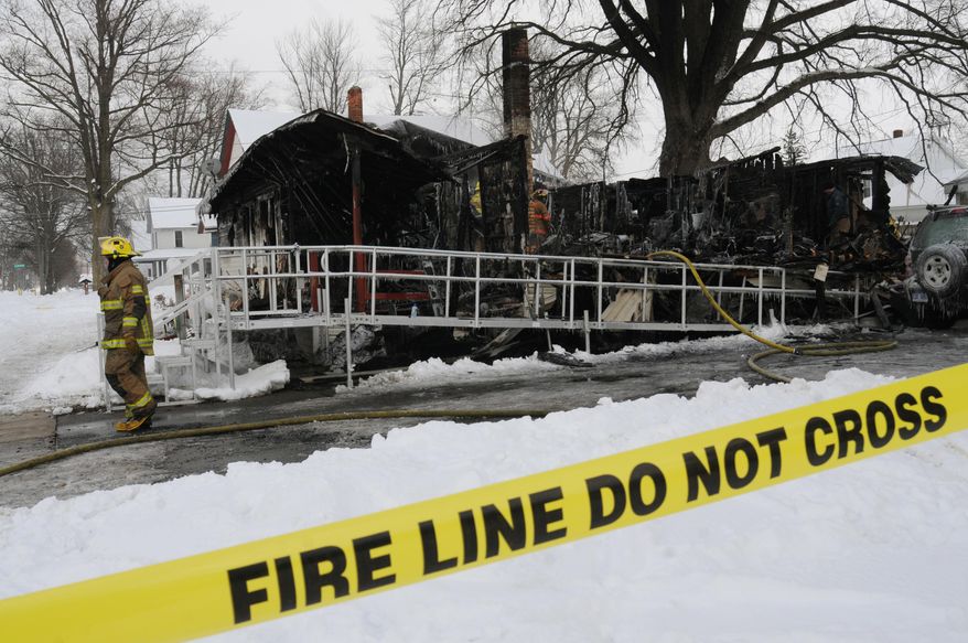 Firefighters work the scene of a house fire along North Elm Street in Three Oaks, Mich., Thursday, Feb. 6, 2014, which left four people dead. The village fire department and state fire marshal's office were investigating. (AP Photo/The Herald-Palladium, Don Campbell)