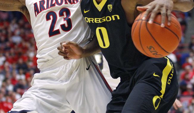 Oregon&#x27;s Mike Moser (0) maneuvers with the ball against Arizona&#x27;s Rondae Hollis-Jeffson (23) in the first half of an NCAA college basketball game Thursday, Feb. 6, 2014, in Tucson, Ariz. (AP Photo/John MIller)